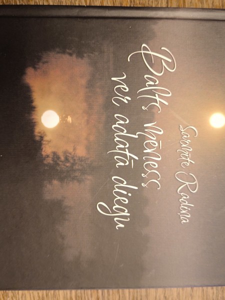 Balts mēness ver adatā diegu